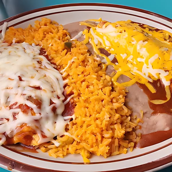 A plate of Mexican food with enchiladas, rice, and refried beans, topped with melted cheese.