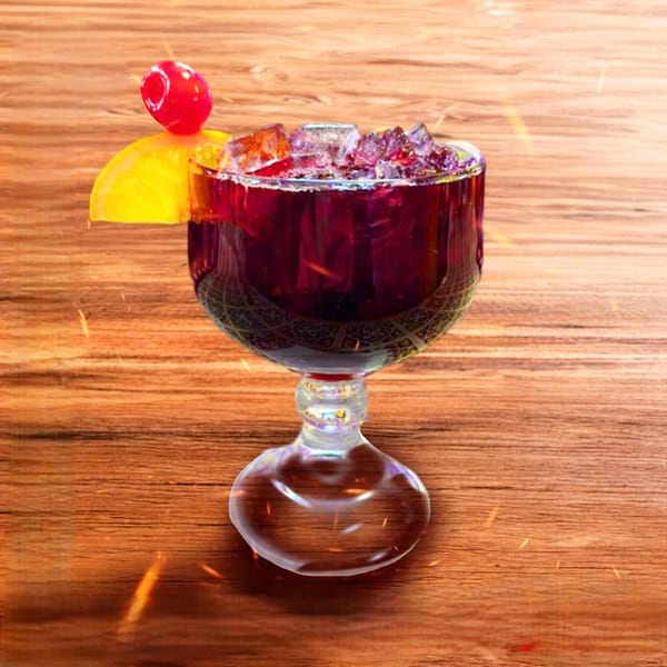 Mexican sangria in a goblet, garnished with a lemon slice and cherry, on a wooden table.